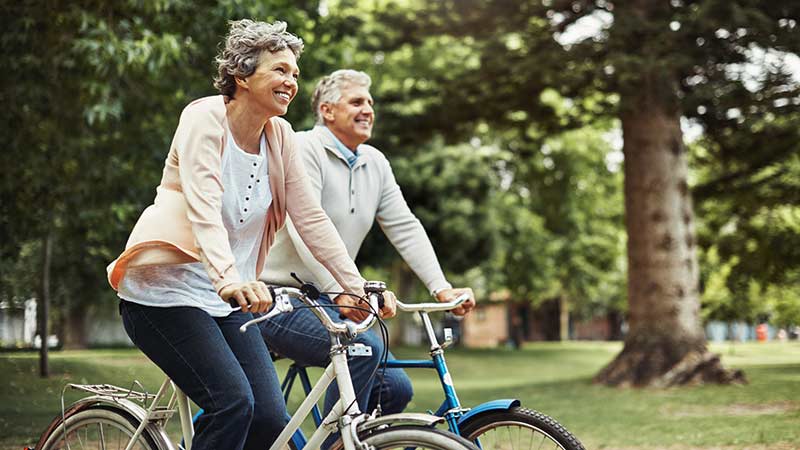 ouder stel in het bos aan het fietsen
